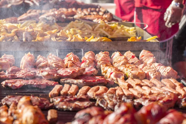 Different kind on grilled meat and sausages with smoke and steam from the grill — Stock Photo, Image