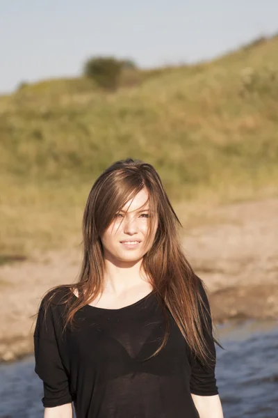 Hermosa chica con el pelo largo y liso posando en el campo buscando melancólico — Foto de Stock