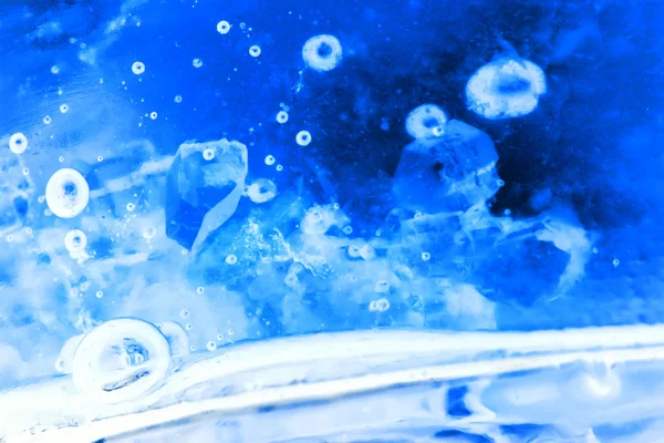 Abstrakt komposition med sockerbitar i en burk med sötma (inverterade färger). Det ser ut som vatten med bubblor och isbitar — Stockfoto