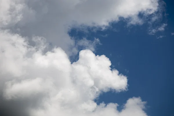 Nuvens bonitas, fofas, brancas e cinzentas e céu azul — Fotografia de Stock