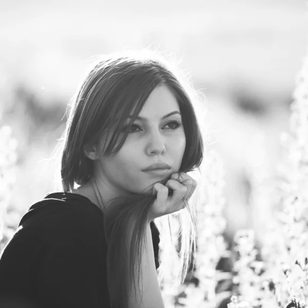 Beautiful girl with long, straight hair posing in the field looking melancholic — Stock Photo, Image