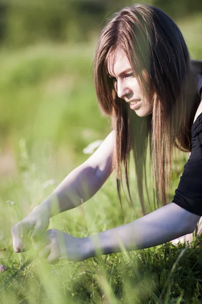 Beautiful girl with long, straight hair posing in the field looking melancholic — Stock Photo, Image