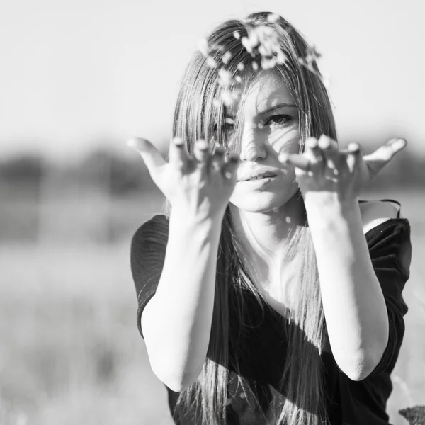 Black and white photo of beautiful girl with long, straight hair posing in the field looking melancholic — Stock Photo, Image