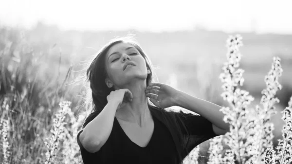 Foto in bianco e nero di bella ragazza con lunghi capelli dritti in posa sul campo cercando malinconico — Foto Stock