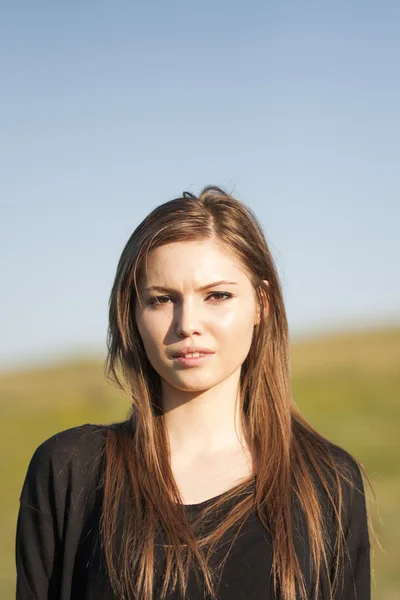 Beautiful girl with long, straight hair posing in the field — Stock Photo, Image