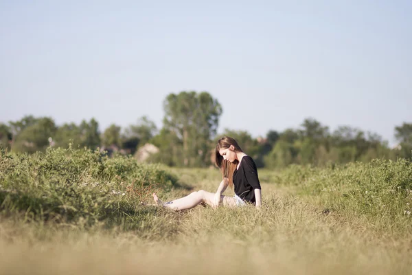 Krásná dívka s dlouhými, rovné vlasy, působícím v oblasti — Stock fotografie