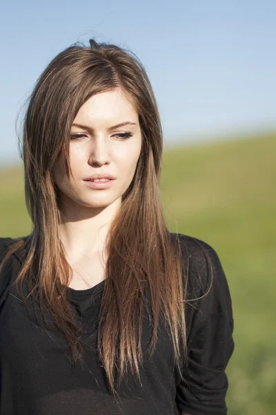 Beautiful girl with long, straight hair posing in the field — Stock Photo, Image