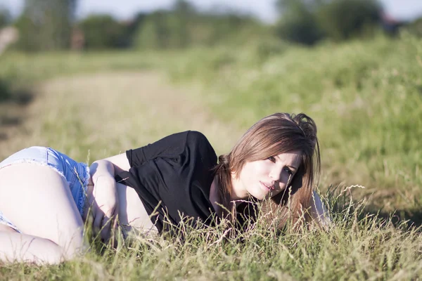 Mooi meisje met lange, rechte haren poseren in het veld — Stockfoto