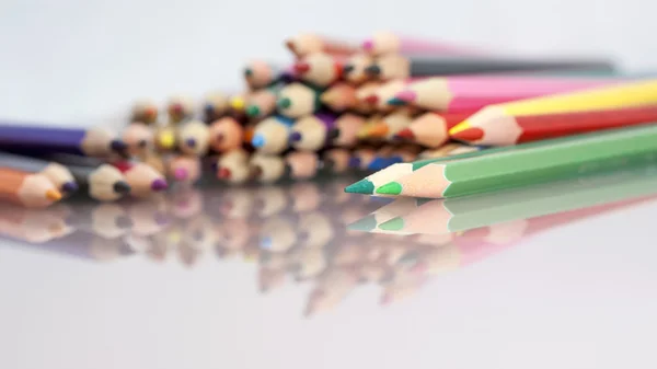 Gruppe af farvede blyanter med hvid baggrund og reflekser - Stock-foto