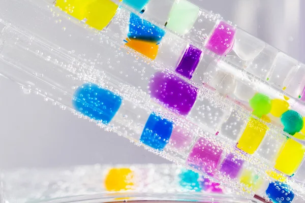 Composição abstrata com tubos subaquáticos com bolas de geleia coloridas dentro e bolhas — Fotografia de Stock