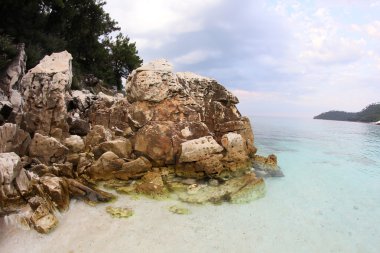 Saliara Beach (denilen mermer Beach), güzel beyaz plaj Thassos Island, Yunanistan. Su ve günbatımı taşlara, yatay