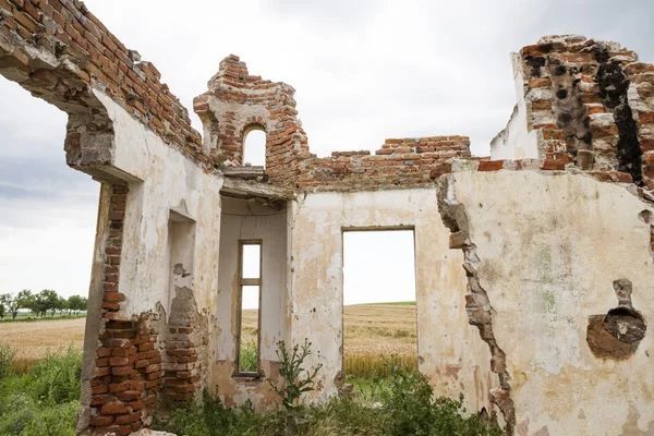 Partes de uma casa arruinada com céu dramático texturas e ervas diferentes — Fotografia de Stock