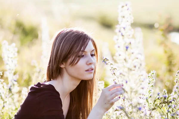 Bella ragazza con lunghi capelli dritti in posa sul campo cercando malinconico — Foto Stock