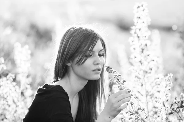 Beautiful girl with long, straight hair posing in the field looking melancholic — Stock Photo, Image