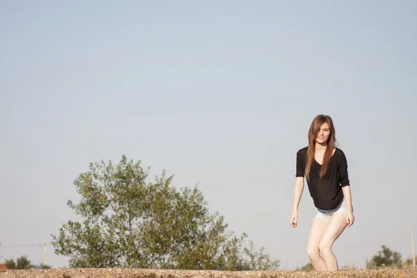Schönes Mädchen mit langen, glatten Haaren posiert auf dem Feld und sieht melancholisch aus — Stockfoto