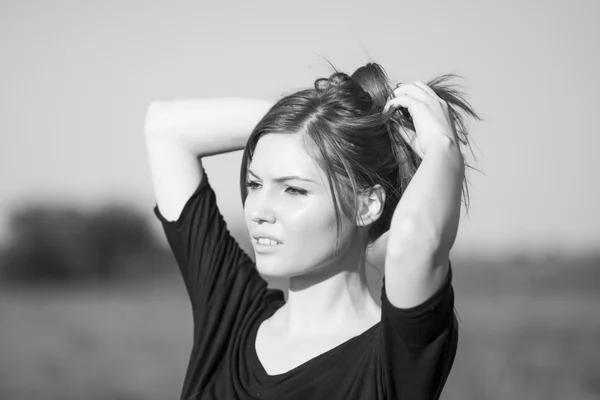 Hermosa chica con el pelo largo y liso posando en el campo buscando melancólico — Foto de Stock