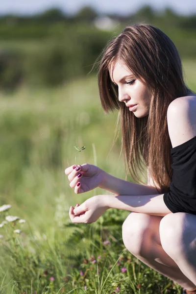 Menina bonita com cabelos longos e lisos posando no campo parecendo melancólica — Fotografia de Stock