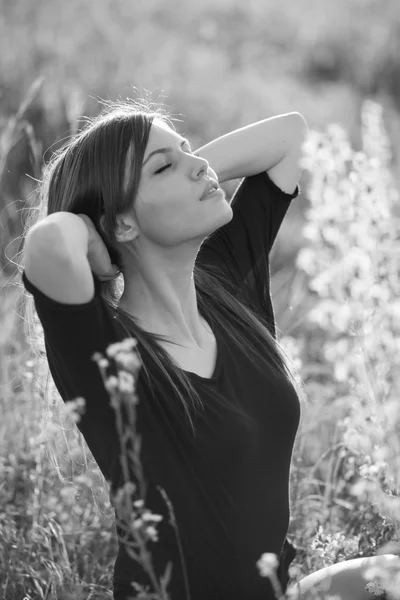 Beautiful girl with long, straight hair posing in the field looking melancholic — Stock Photo, Image