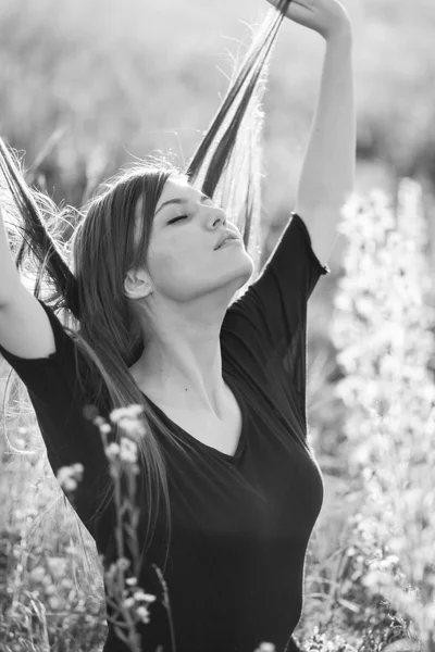 Beautiful girl with long, straight hair posing in the field looking melancholic — Stock Photo, Image