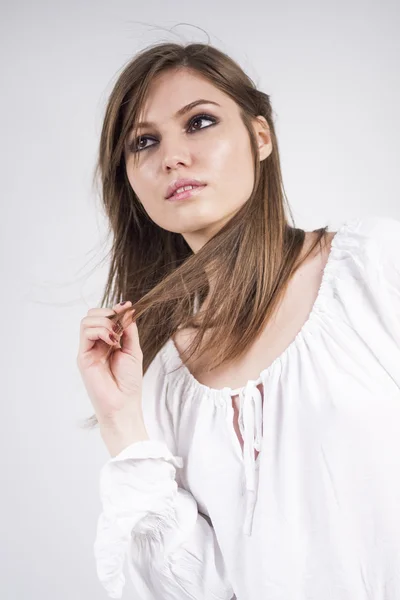 Beautiful caucasian girl wearing a white blouse with light grey background — Stock Photo, Image