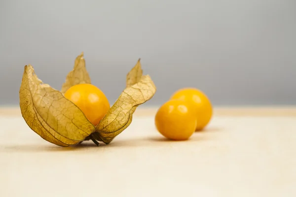 Primer plano de Physalis peruviana frutas con fondo gris claro y reflexiones —  Fotos de Stock