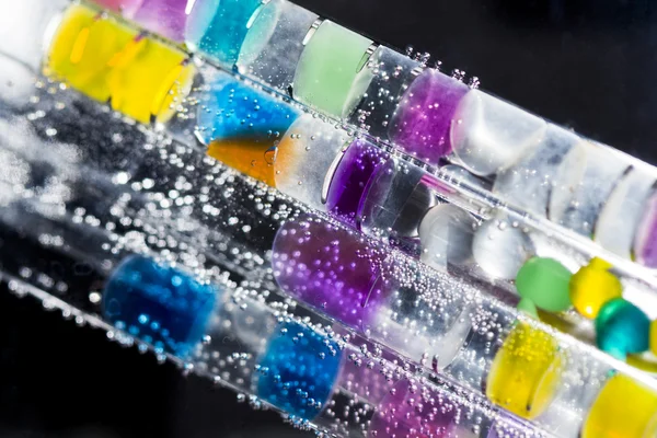 Abstract composition with underwater tubes with colorful jelly balls inside and bubbles — Stock Photo, Image