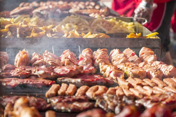 Diferentes tipos de carne a la parrilla y embutidos con humo y vapor de la parrilla — Foto de Stock