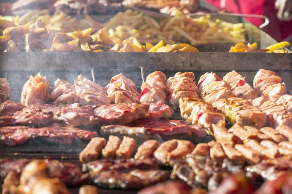 Different kind on grilled meat and sausages with smoke and steam from the grill — Stock Photo, Image