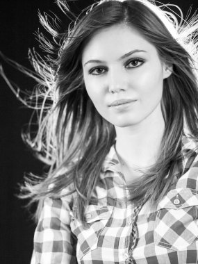 Güzel beyaz uzun saçlı kız koyu arka plan ve kontur ışık ile poz