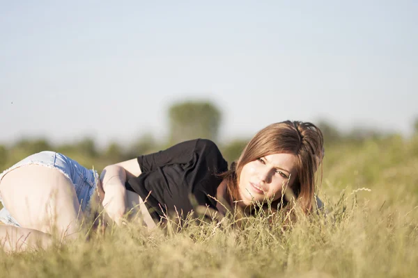 Mooi meisje met lange, rechte haren poseren in het veld — Stockfoto