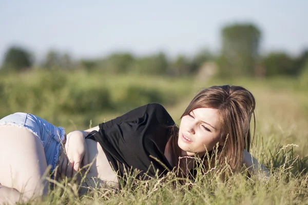 Mooi meisje met lange, rechte haren poseren in het veld — Stockfoto