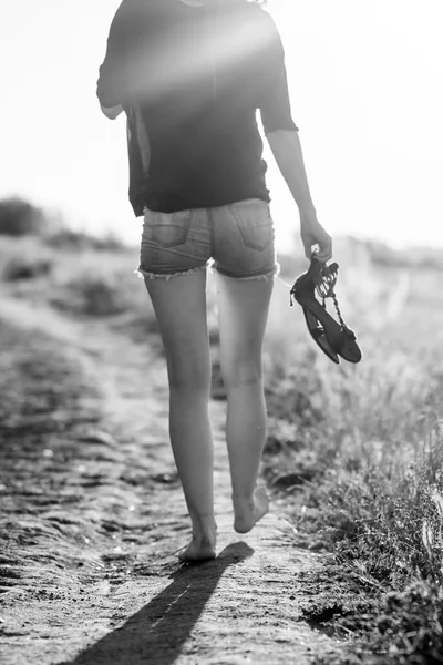 Beautiful girl with long, straight hair posing and playing with water in a small river. Black and white, artistic photography — Stock Photo, Image