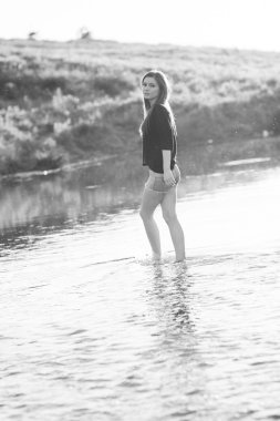 poz ve küçük bir nehir su ile oynarken düz saçlı güzel kız