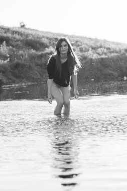 poz ve küçük bir nehir su ile oynarken düz saçlı güzel kız