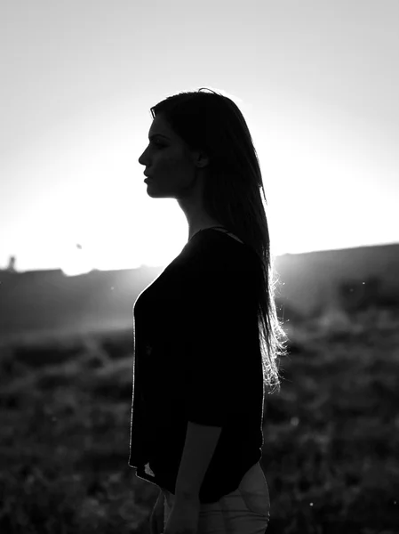 Silueta de mujer en la luz del atardecer. Blanco y negro, fotografía artística — Foto de Stock