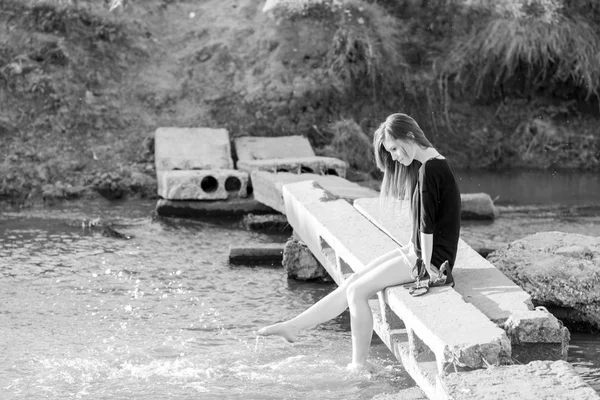 poz ve küçük bir nehir su ile oynarken düz saçlı güzel kız