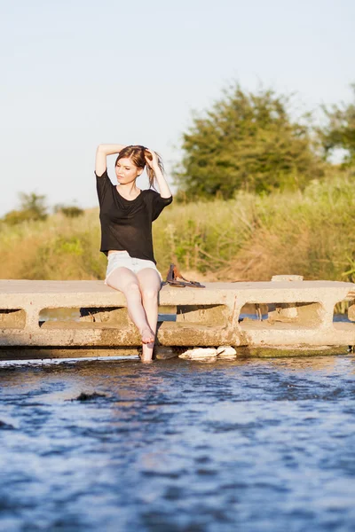 poz ve küçük bir nehir su ile oynarken düz saçlı güzel kız
