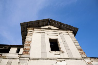 Eski, terk edilmiş taş cephesi ile uzun boylu windows ve mavi gökyüzü arka planda Bina