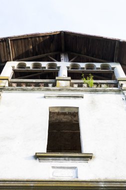 Eski, terk edilmiş taş cephesi ile uzun boylu windows ve mavi gökyüzü arka planda Bina