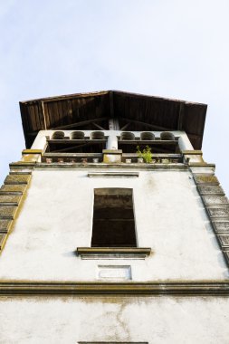 Eski, terk edilmiş taş cephesi ile uzun boylu windows ve mavi gökyüzü arka planda Bina