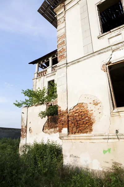 Antigua fachada de piedra de construcción abandonada con ventanas altas y cielo azul al fondo —  Fotos de Stock