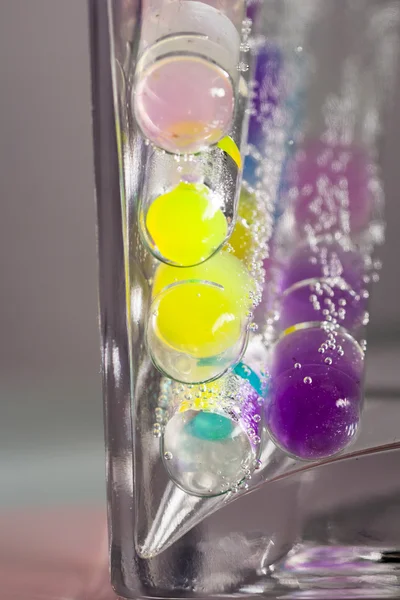 Abstract composition with underwater tubes with colorful jelly balls inside and bubbles — Stock Photo, Image