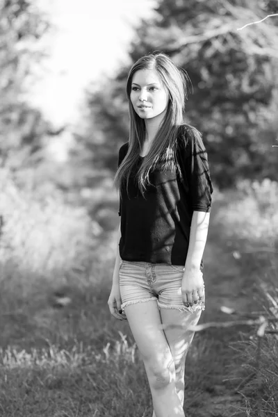 Beautiful girl with long, straight hair posing and playing with water in a small river. Black and white, artistic photography — Stock Photo, Image