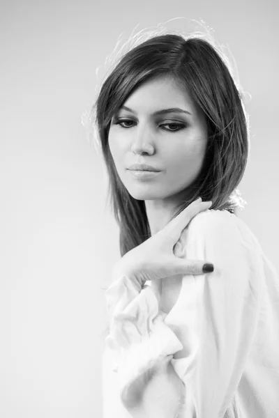 Photo noir et blanc de belle fille caucasienne portant un chemisier blanc avec fond gris clair — Photo