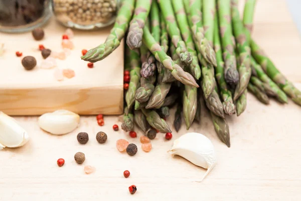 Fresh asparagus stems with spices and garlic — Stock Photo, Image
