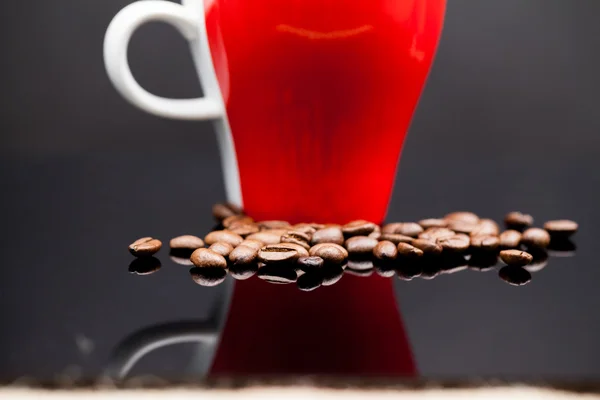 Xícara vermelha de café com grãos de café — Fotografia de Stock