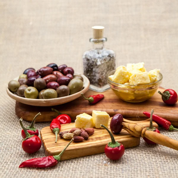 Composición con madera de olivo, aceitunas, vinagre y especias con textura de arpillera —  Fotos de Stock