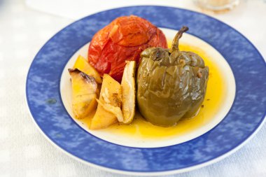 Doldurulmuş sebze ve sos mavi plaka üzerinde