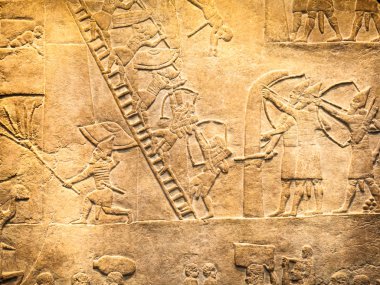 29. 07. 2015, Londra, İngiltere, British Museum - Asur duvarından arka planda Mısır binaları gösteren ayrıntılar. Ön planda, Nubia'lı mahkum tüy şapka giymek.