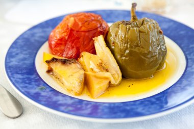 Doldurulmuş sebze ve sos mavi plaka üzerinde